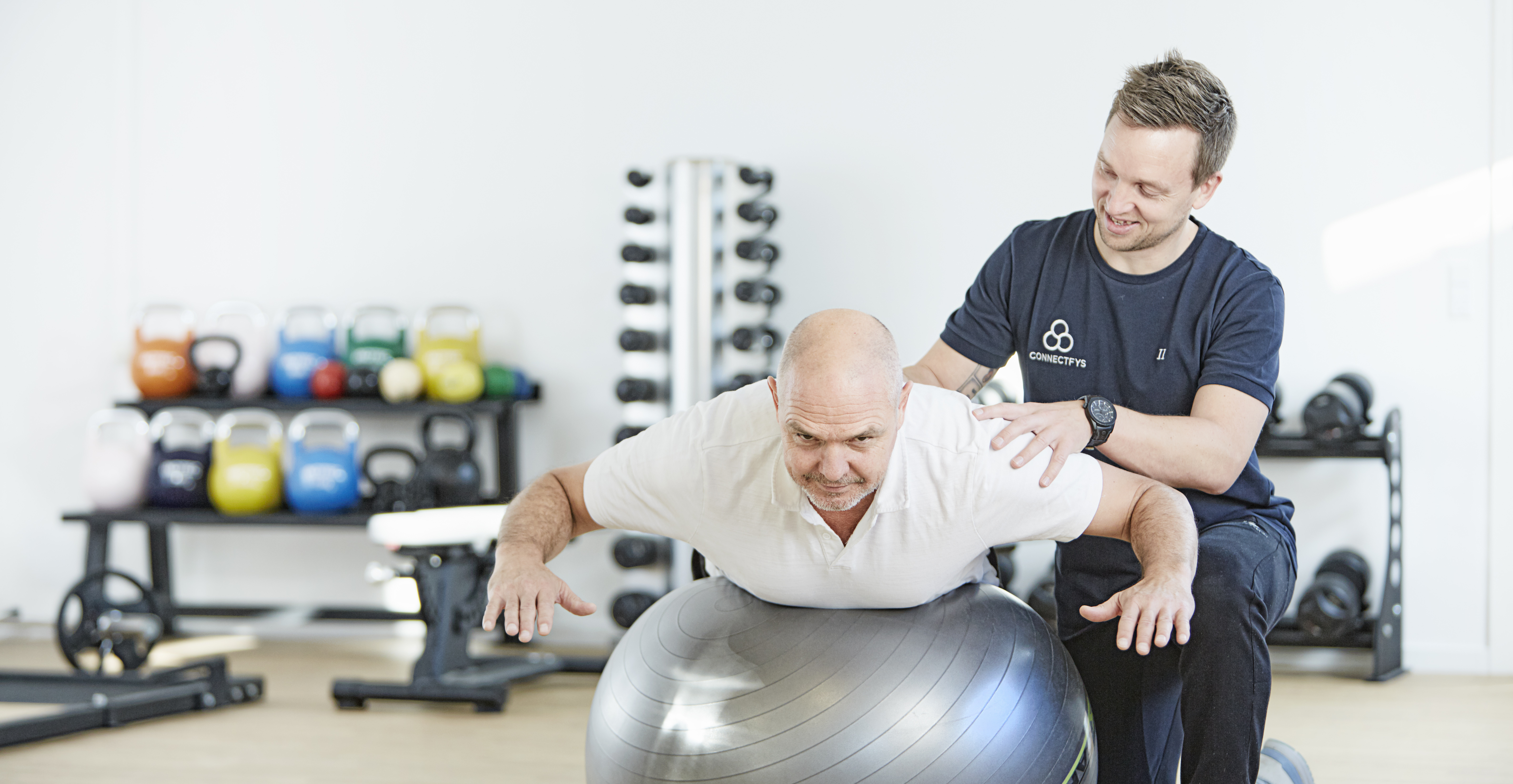 Billedet viser en fysioterapeut, der træner med en patient.