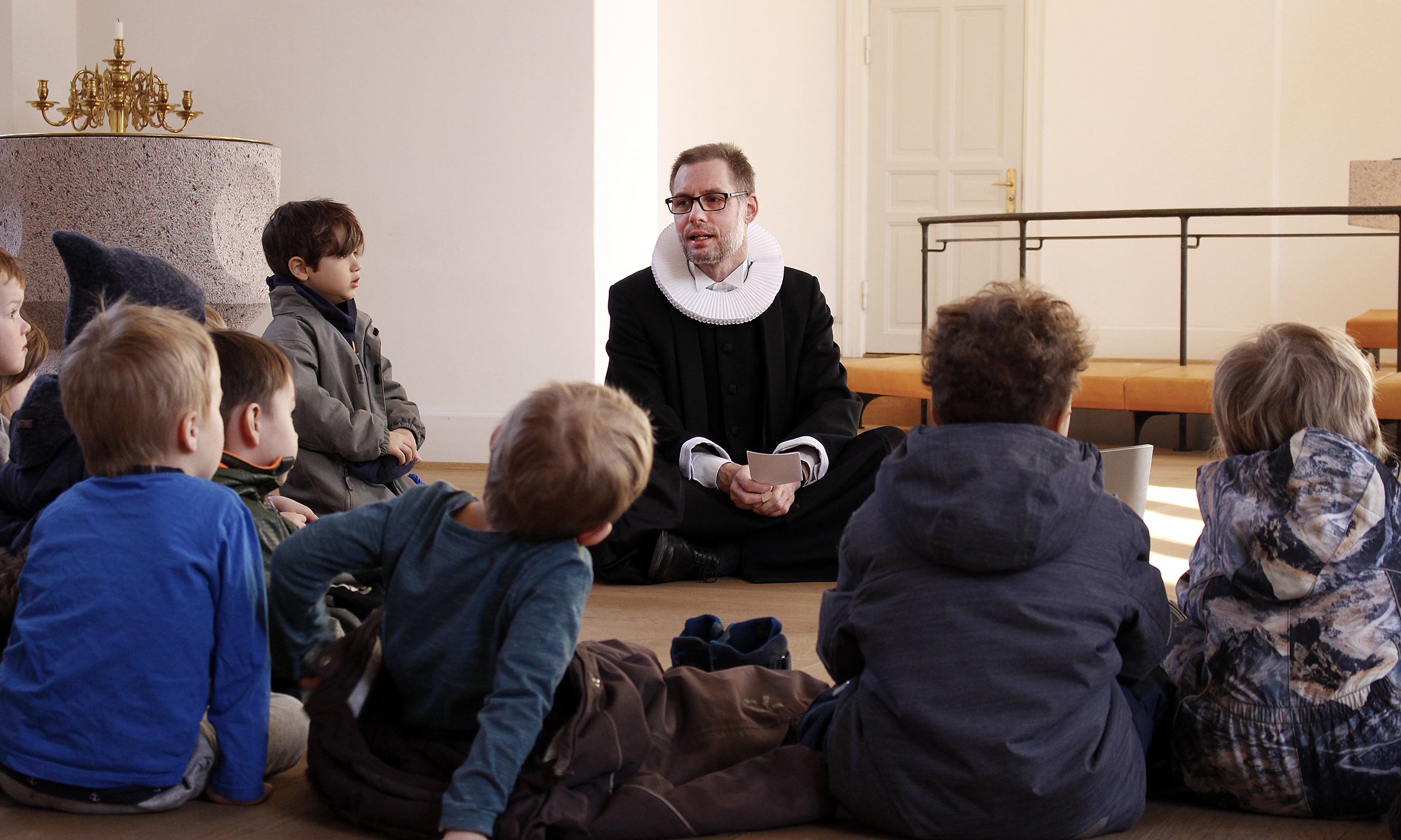 Billedet viser præst Jan Nilsson, der taler med børn fra Louisegården.