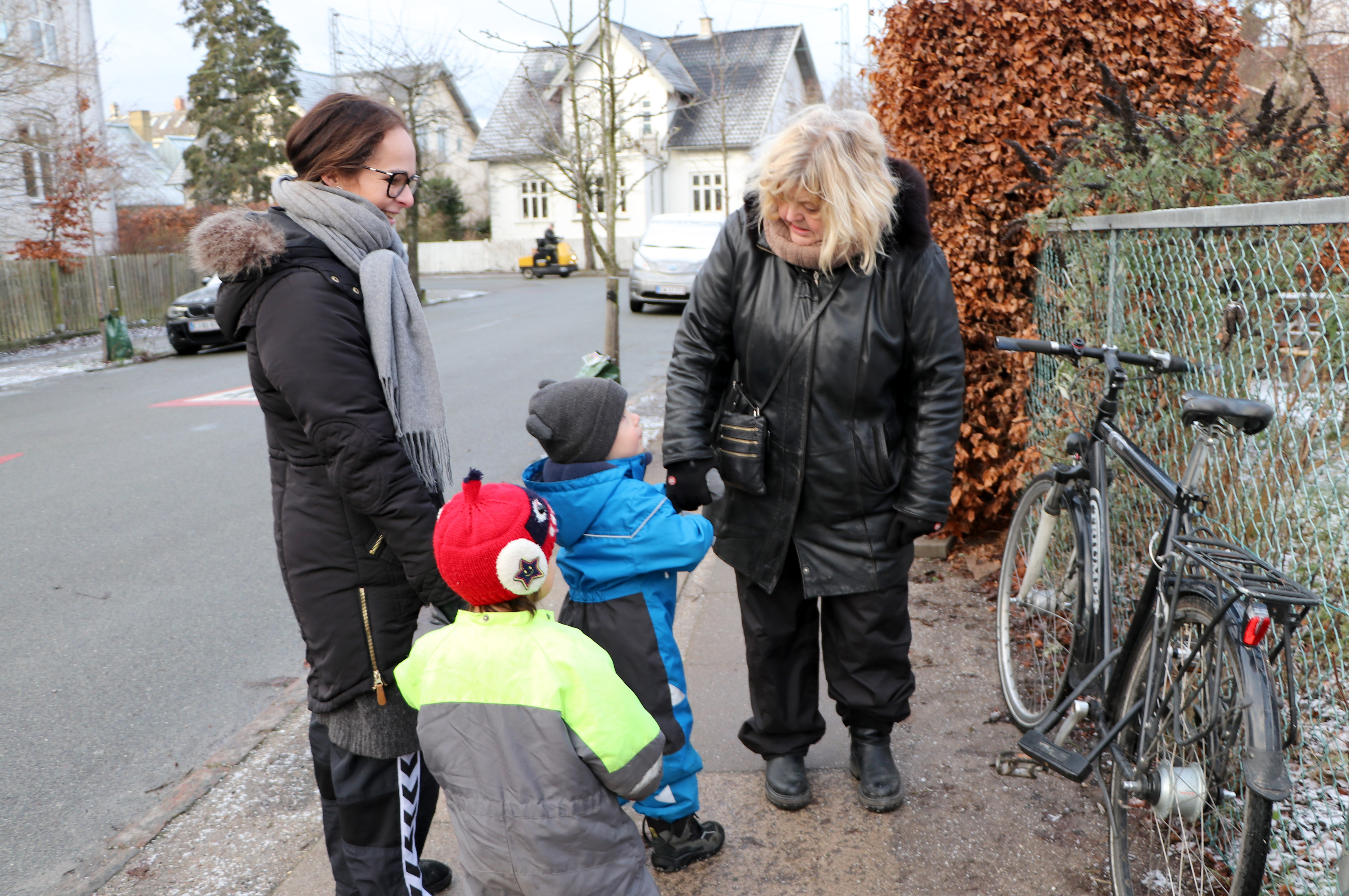 To voksne og to børn kigger på en cykel.