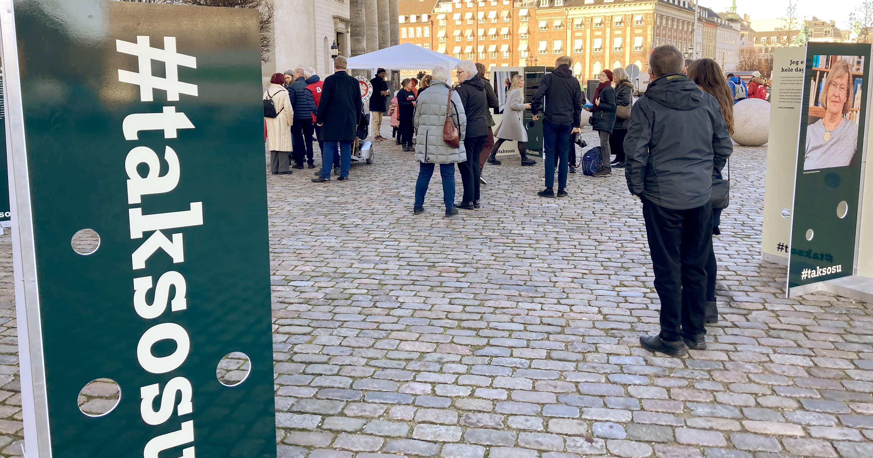 Mennesker og skilte på Christiansborg Slotsplads.