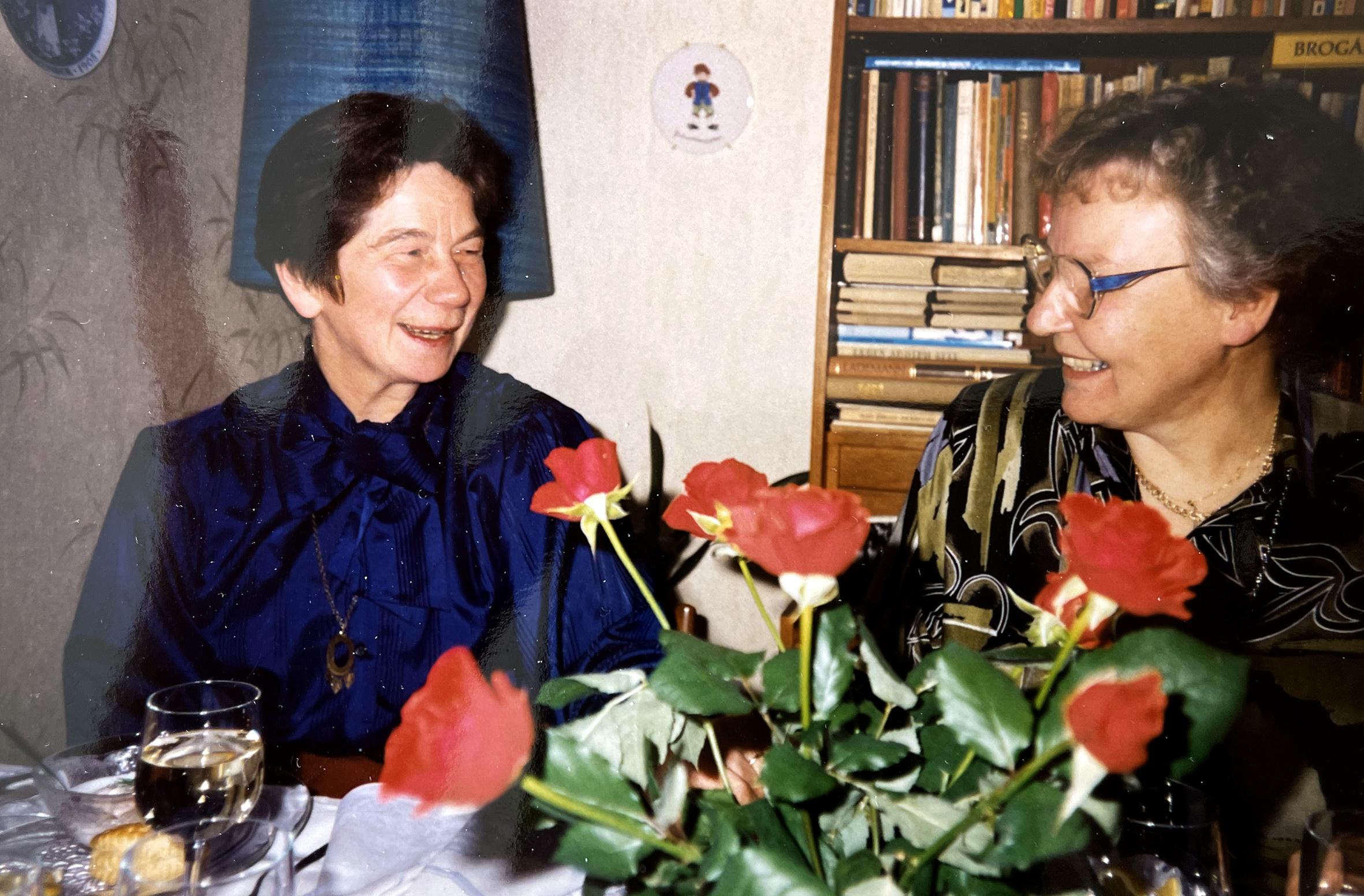 Billedet viser to kvinder ved et dækket bord.