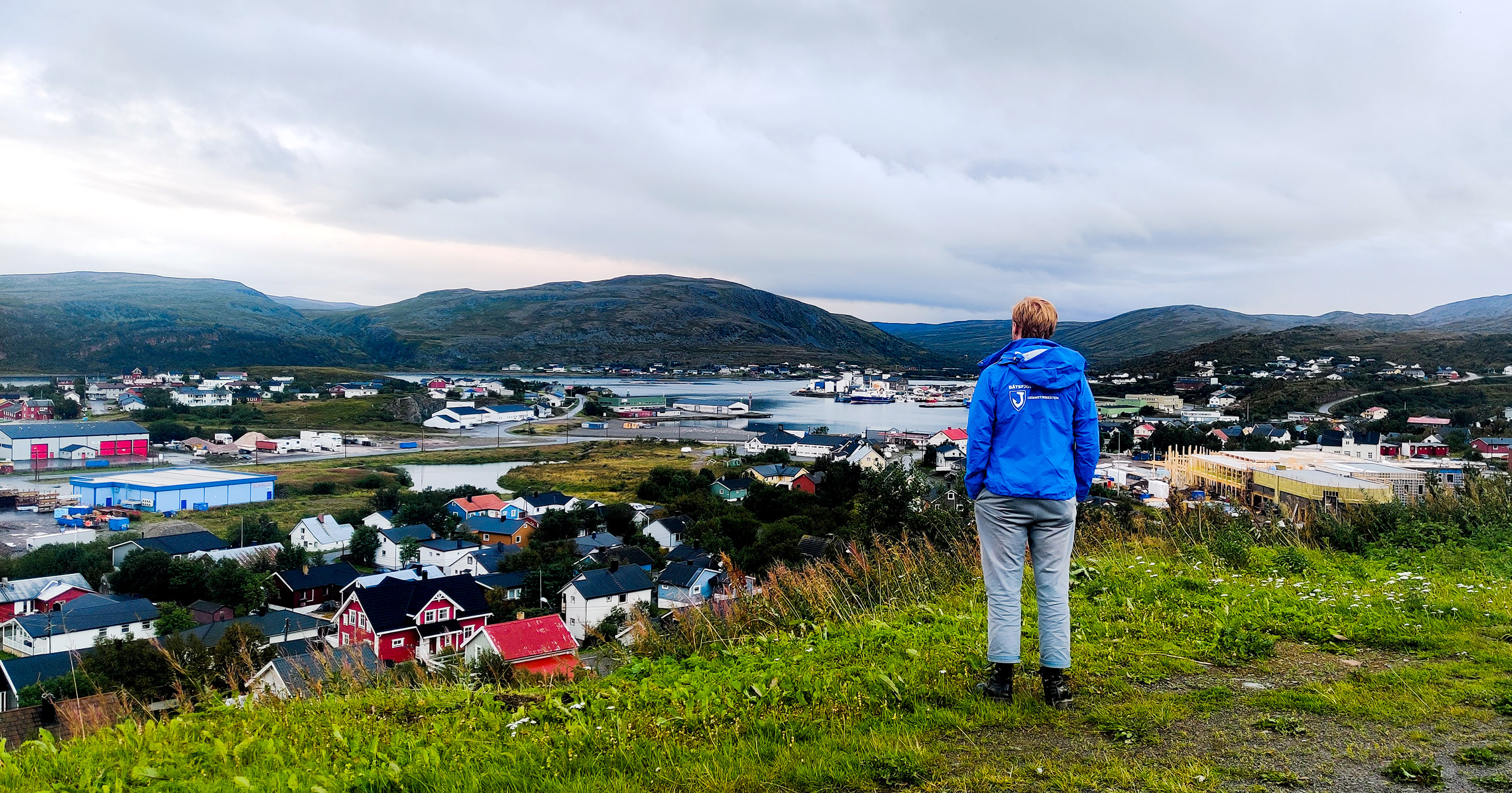 En ung mand står og kigger ud over et norsk landskab.