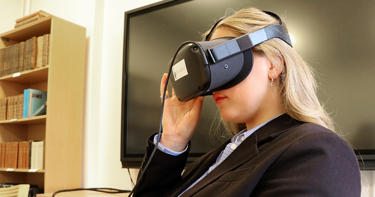 Billedet viser en kvinde med et virtual reality headset på hovedet.