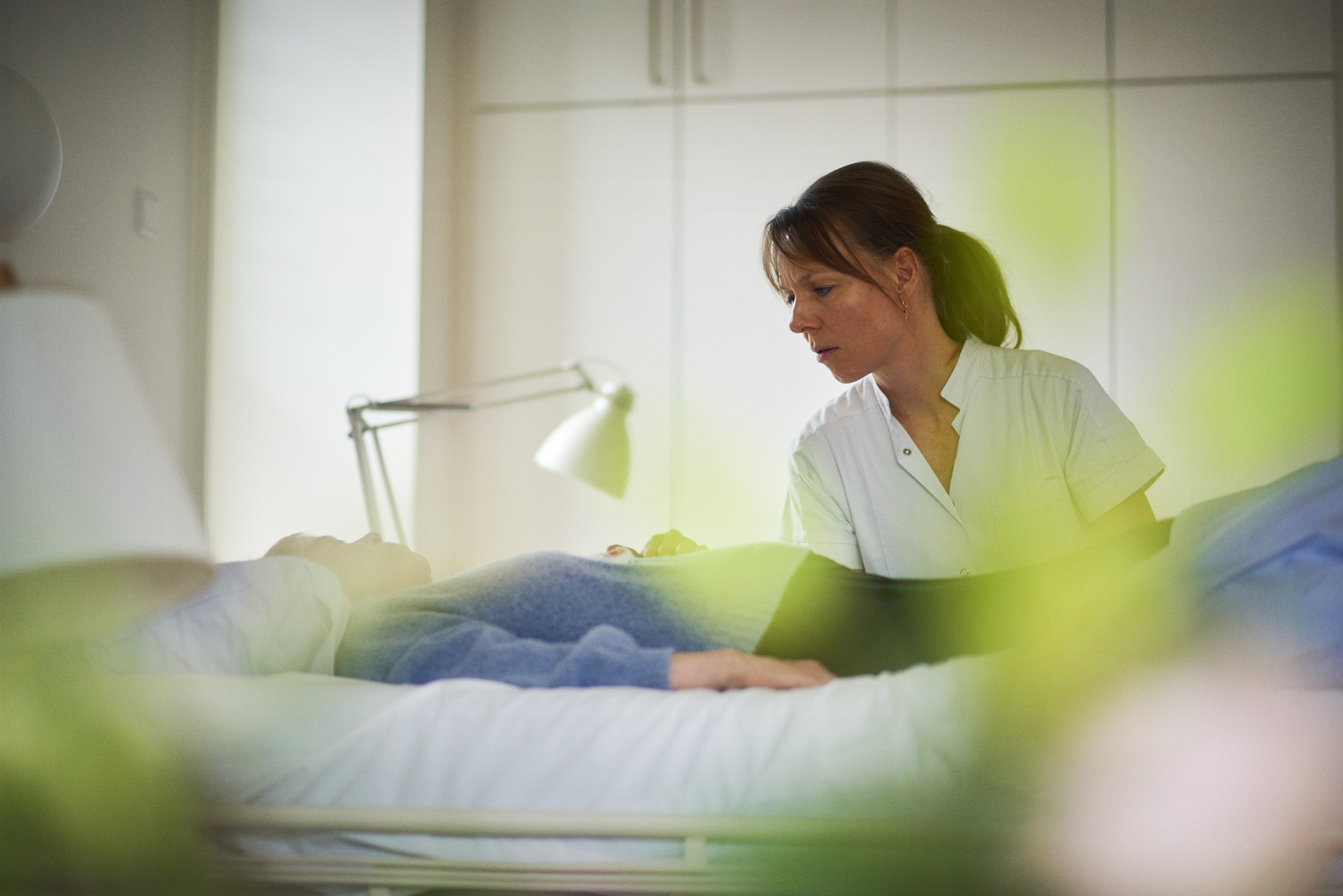 Billedet viser en patient og en medarbejder.