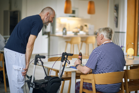 Billedet viser en patient og en medarbejder.